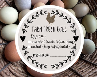 May include: A round sticker with a beige background featuring a brown chicken silhouette, a black leaf wreath, and two hearts. The text reads: FARM FRESH EGGS, Eggs are: unwashed (wash before using), washed (keep refrigerated), and PACKED ON:.