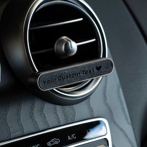 Può includere: Clip per bocchette di ventilazione dell'auto nero con il testo "Your Custom Text" e un simbolo di cuore.