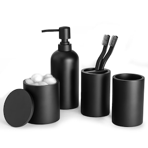 May include: A black bathroom set with a soap dispenser, a cotton ball holder with a lid, and a toothbrush holder with two toothbrushes.