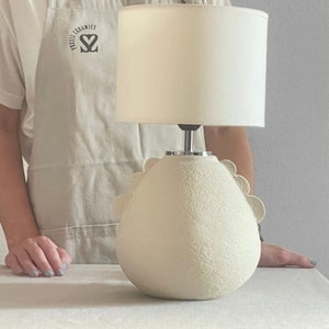 image of a lamp with a girl behind it, you can see the full size of the lamp, base + lamp shade, from the girl's pubic area to the upper chest area.