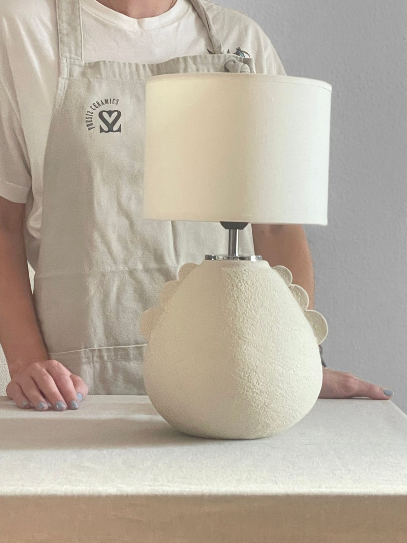 image of a lamp with a girl behind it, you can see the full size of the lamp, base + lamp shade, from the girl's pubic area to the upper chest area.