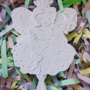 May include: White ceramic fairy figurine with a crown, wings, and a wand. The fairy is wearing a dress with a bow and is holding a bouquet of flowers.