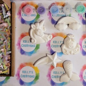 Puede incluir: Un kit de cer&aacute;mica para pintar con seis figuritas de cer&aacute;mica blanca: un unicornio, un arco&iacute;ris, una cola de sirena, una estrella, una princesa y una sirena. El kit incluye cinco peque&ntilde;os botes de pintura y un pincel morado. El kit est&aacute; empaquetado en una caja de cart&oacute;n con papel de seda de colores.