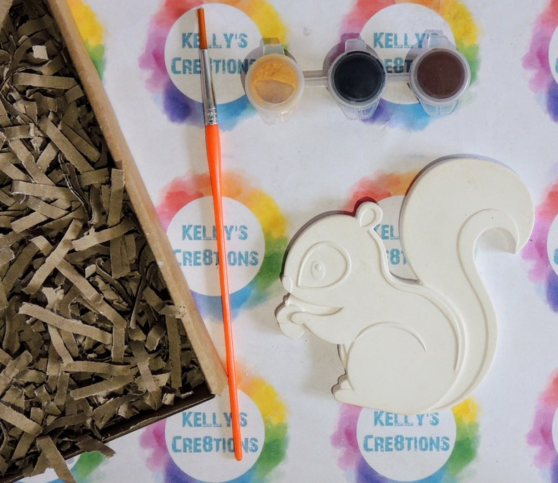 K&ouml;nnte beinhalten: Eine wei&szlig;e Keramik-Eichh&ouml;rnchenfigur mit einem Malen-nach-Zahlen-Design. Das Set enth&auml;lt drei kleine Farbt&ouml;pfe, einen Pinsel und einen kleinen Beh&auml;lter mit gelber Farbe.