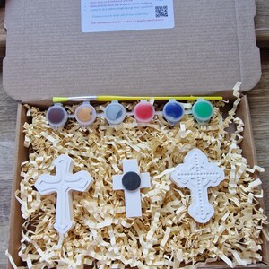three white plaster cross, in bow with paints and brush