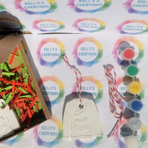 Pu&ograve; includere: Un ornamento in ceramica bianca a forma di maglione con un disegno di pupazzo di neve. L'ornamento &egrave; confezionato in una scatola con carta triturata rossa e verde. L'ornamento &egrave; fornito con uno spago rosso e bianco e un set di barattoli di vernice e un pennello.