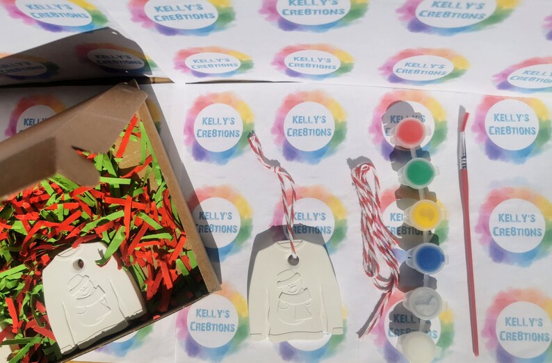 Pu&ograve; includere: Un ornamento in ceramica bianca a forma di maglione con un disegno di pupazzo di neve. L'ornamento &egrave; confezionato in una scatola con carta triturata rossa e verde. L'ornamento &egrave; fornito con uno spago rosso e bianco e un set di barattoli di vernice e un pennello.