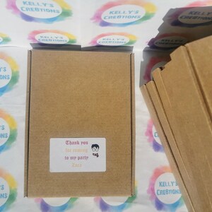 May include: A brown cardboard box with a white sticker that reads "Thank you for coming to my party Zara". The box is surrounded by colorful stickers with the text "Kelly's Creations".