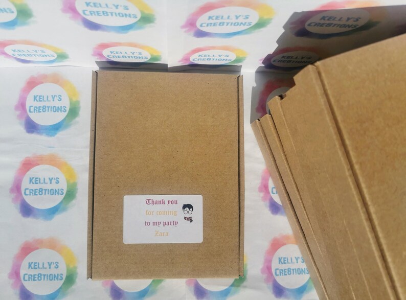 May include: A brown cardboard box with a white sticker that reads "Thank you for coming to my party Zara". The box is surrounded by colorful stickers with the text "Kelly's Creations".