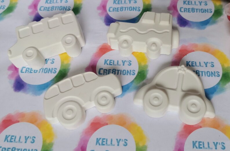 May include: Five white ceramic car figurines, each with a different design. The cars are ready to be painted.