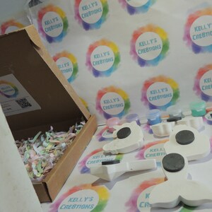 Puede incluir: Un kit de manualidades con formas de unicornio, sirena y otras en cer&aacute;mica blanca con imanes en la parte posterior. El kit incluye botes de pintura de varios colores, un pincel y una caja llena de papel de seda de colores.