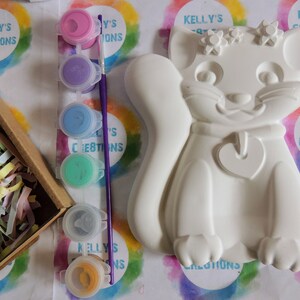 Pu&ograve; includere: Una statuetta di gatto in ceramica bianca con un ciondolo a forma di cuore e dettagli floreali. La statuetta &egrave; pronta per essere dipinta con il set di colori acrilici incluso.