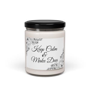 May include: A white candle jar with a black lid and a white label that says "Keep Calm & Make Dua" with black floral designs on the label.