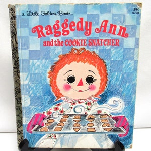 May include: A vintage Little Golden Book featuring Raggedy Ann and the Cookie Snatcher. The cover features a colorful illustration of Raggedy Ann holding a baking sheet full of cookies.