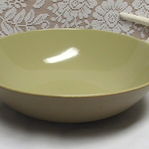May include: A large, light green ceramic serving bowl. The bowl is round and has a smooth, glossy finish.