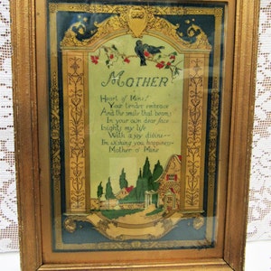May include: A framed vintage poem about motherhood with a gold frame and a blue and gold background. The poem reads "Mother, Heart of Mine! Your tender embrace and the smile that beams in your own dear face lights my life with a joy divine. I'm wishing you happiness - Mother o' Mine."