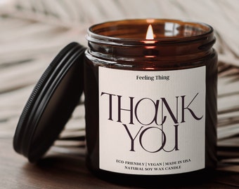 Może przedstawiać: Szklany słoik z brązowego szkła z białą etykietą, na której widnieje napis "Feeling Thing" i "THANK YOU". Etykieta zawiera również napis "ECO-FRIENDLY | VEGAN | MADE IN USA | NATURAL SOY WAX CANDLE".
