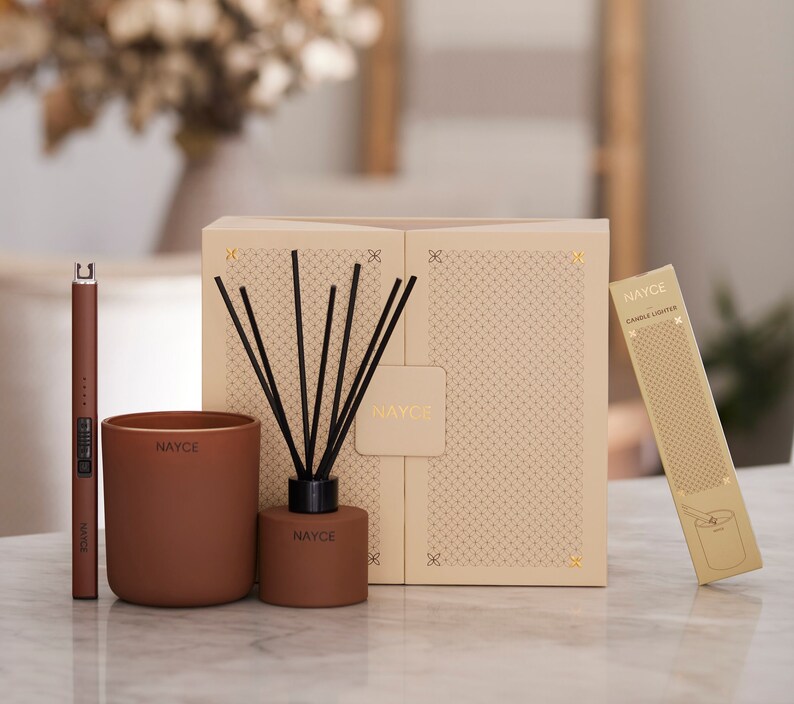 May include: A gift set featuring a brown candle, a diffuser with black reeds, a candle lighter, and a box with the word "NAYCE" printed on it.