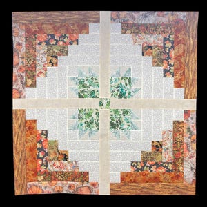 May include: A handmade quilt with a patchwork design. The quilt features a central cross pattern in light beige, with sections of white and various autumn-themed fabrics. These fabrics include pumpkins, leaves, and floral patterns in shades of orange, brown, and green.
