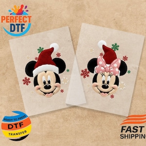 Könnte beinhalten: Zwei bügelfähige DTF-Transfers mit Mickey und Minnie Mouse mit Weihnachtsmützen. Mickey hat einen roten Hut mit weißem Rand, Minnie eine rosa Schleife. Beide haben Schneeflocken-Akzente. Der Text "READY TO PRESS DTF TRANSFER" ist enthalten.