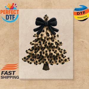 May include: A Christmas tree design with a leopard print pattern. The tree is brown and tan with black spots, topped with a black bow. The image has the text "PERFECT DTF" and "READY TO PRESS DTF TRANSFER".