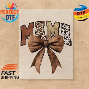 May include: A tan graphic with the word "MAMA" in brown, leopard print, and gold glitter lettering, topped with a large brown bow. The image is ready to press for DTF transfer.