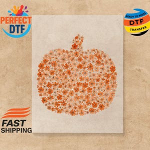 Può includere: Un foglio di trasferimento DTF rettangolare beige con un disegno di zucca fatto di fiori arancioni. Le parole "PERFECT DTF" e "READY TO PRESS DTF TRANSFER" sono stampate sul foglio. Anche le parole "FAST SHIPPING" sono stampate.