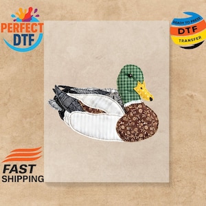 以下が含まれることがあります： 緑のチェック柄の頭、茶色の花柄の体、白いストライプの胸を持つ布製のアヒルのアップリケ。アヒルは黄色のくちばしとグレーと黒の翼を持っています。画像には「PERFECT DTF」と「READY TO PRESS DTF TRANSFER」の文字が含まれています。