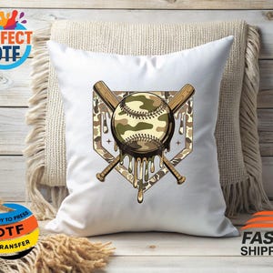 May include: White baseball-themed cushion featuring a camouflage baseball design, two crossed bats, and a home plate outline. The baseball has a dripping effect. The cushion is on a neutral-toned throw.