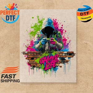 Könnte beinhalten: Digitaldruck mit einer Person in einem Kapuzenpullover, die ein Videospiel spielt, mit bunten Farbspritzern und dem Text "Gamer Life". Das Bild enthält auch den Text "Perfect DTF" und "Ready to Press DTF Transfer."