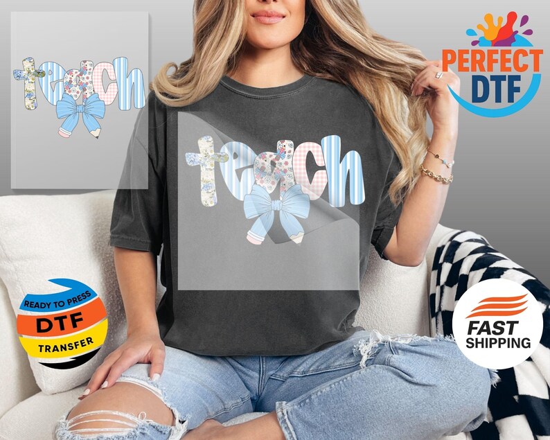 May include: A dark gray t-shirt featuring the word "Teach" in a whimsical design. The letters are adorned with floral patterns, blue stripes, and a light blue bow. The design is likely a DTF transfer.