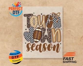 May include: A football-themed design with the words "Touchdown Season" in brown, white, and black. The letters are decorated with leopard print, checkered patterns, and a football graphic. The design is on a beige background.