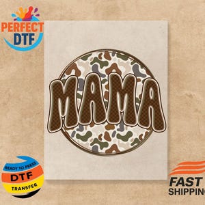 May include: A beige background with a circular design featuring the word "MAMA" in a brown, checkered font. The circle has a camouflage pattern in shades of brown, green, and beige. The image also includes the text "PERFECT DTF" and "READY TO PRESS DTF TRANSFER".