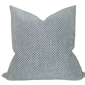 May include: A square cushion featuring a white and navy blue geometric pattern. The cushion has a soft, textured appearance and a classic design, suitable for adding a touch of style to any living space.