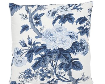 May include: Square throw pillow with a white background and a blue floral pattern. The design features large roses, leaves, and branches in varying shades of blue, creating a classic, elegant look.