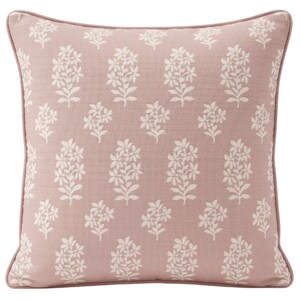 May include: A square throw pillow in a dusty rose pink color featuring a repeating off-white floral pattern of small sprigs. The pillow is finished with matching pink piping along all four edges, creating a clean and defined border.
