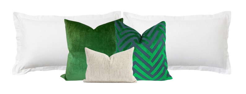 May include: Four decorative throw pillows, two white, one green velvet, one green and blue geometric pattern.