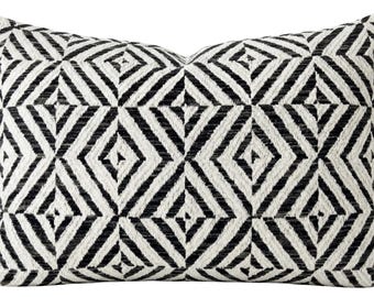 May include: A rectangular throw pillow featuring a high-contrast black and white geometric pattern. The design consists of repeating diamond shapes formed by diagonal lines, creating a textured, woven appearance across the entire surface.