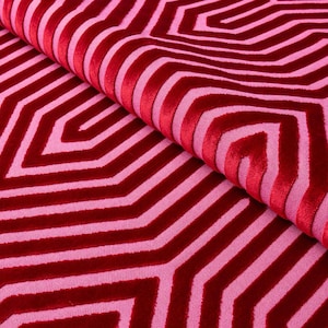 May include: Red and pink fabric with a geometric pattern of overlapping stripes and hexagons.