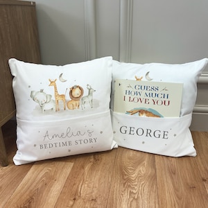 May include: Two white pillow covers with pockets. One pillow features a print of a giraffe, elephant, lion, and zebra with the text "Amelia's Bedtime Story". The other pillow has a book titled "Guess How Much I Love You" in the pocket and the text "GEORGE".