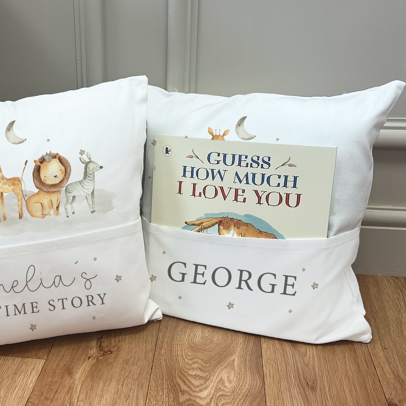 May include: Two white pillow covers with pockets for books. The pillow on the left has a print of animals and the text "Amelia's Time Story". The pillow on the right has a print of stars and the text "GEORGE". A book titled "Guess How Much I Love You" is in the pocket of the pillow on the right.