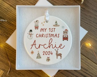 Könnte beinhalten: Weißer Keramik-Weihnachtsbaumschmuck mit einem roten und weißen Schneemann, einer roten und weißen Maus, einem roten und weißen Bären, einem roten und weißen Rentier, einem roten und weißen Weihnachtsbaum, einer roten und weißen Geschenkbox und dem Text "My 1st Christmas Archie 2024".