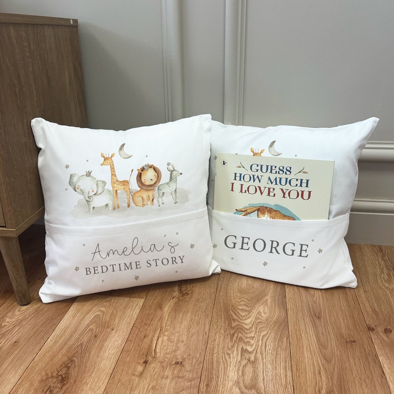 May include: Two white pillow covers with pockets. One pillow features a print of a giraffe, elephant, lion, and zebra with the text "Amelia's Bedtime Story". The other pillow has a book titled "Guess How Much I Love You" in the pocket and the text "GEORGE".