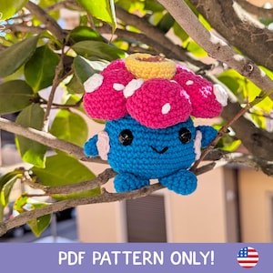 May include: A crochet pattern for a blue and pink Pokemon character with a flower on its head. The pattern is available as a PDF download.  PDF PATTERN ONLY!