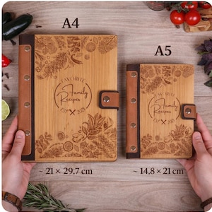 May include: Two wooden recipe books, A4 and A5 sizes, with brown leather accents. The covers are engraved with botanical designs and the text "FAVORITE Family Recipes EST X 2021". The A4 book measures approximately 8.3 x 11.7 inches, and the A5 book is about 5.8 x 8.3 inches.