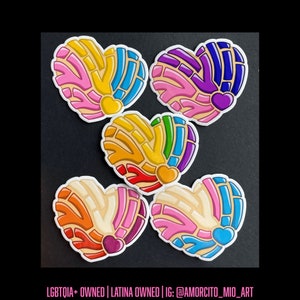 May include: Five heart-shaped stickers featuring a concha bread pattern with various color combinations including pink, yellow, blue, purple, green, orange, and white. Each sticker has a small solid heart icon at the bottom center.