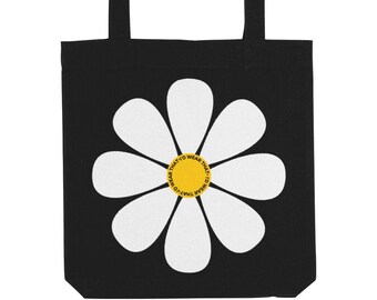 May include: Black tote bag with a white daisy flower design. The center of the flower has a yellow circle with the text "I'd wear that, I'd wear that, I'd wear that, I'd wear that" repeated around the circle.