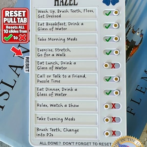 May include: A white plastic daily routine checklist board titled FORGET-ME-NOT HAZEL with a blue flower graphic. It features ten rows of tasks with sliding toggles showing green checkmarks or red X symbols, and a side reset pull tab for the sliders.