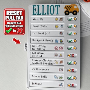 May include: A white plastic chore chart for Elliot featuring a yellow dump truck graphic. It lists ten daily tasks including Wash Up, Brush Teeth, and Bedtime, each with a sliding toggle to mark completion with a green check or red X symbol.