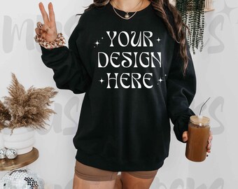 May include: A black sweatshirt with the text "YOUR DESIGN HERE" in white lettering. The sweatshirt has a crew neck and long sleeves.